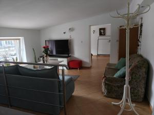 a living room with a couch and a table at Studio dwupokojowe z łazienką i kuchnią in Augustów