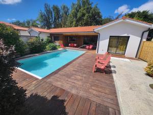 a backyard with a swimming pool and a wooden deck at Maison centre-ville , pisicne in Mimizan