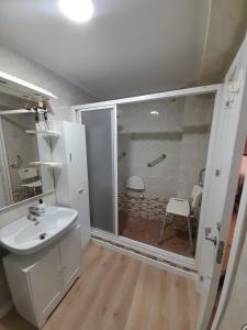 a bathroom with a white sink and a shower at Alojamiento El Sevillano in Cullera
