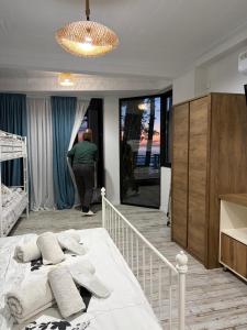 Ein Mann steht in einem Schlafzimmer mit einem Bett. in der Unterkunft Mana-Mana in Grigoleti