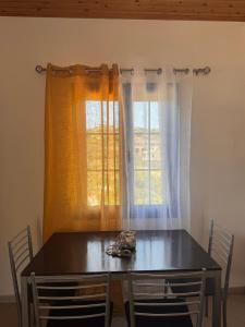 a dining room table with chairs and a window at LifeHouse in Agia Pelagia