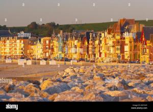 a group of buildings on a beach with rocks at L'escale in Mers-les-Bains