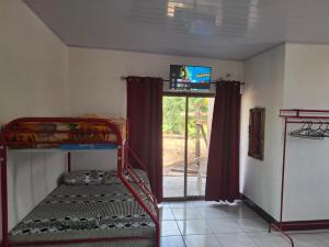 a room with a bunk bed with a tv and a window at Mandy's Villa in Bluefields