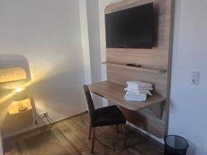 a room with a desk with a television and a chair at Voigt's Hofpension GbR in Zahna-Elster