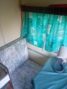 a couch and a lamp in a room with a window at Yupfssi camp in Riga