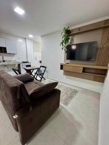 a living room with a couch and a flat screen tv at No centro, em frente à praça in Eunápolis