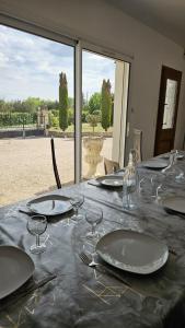 a table with plates and wine glasses on it at La bâtisse a deux tours in Lalbenque