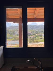 two windows above a sink in a kitchen with a view at LifeHouse in Agia Pelagia +2 photos