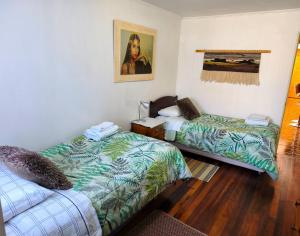 a room with two beds and a painting on the wall at Donde Mauricio in Coihaique +4 photos