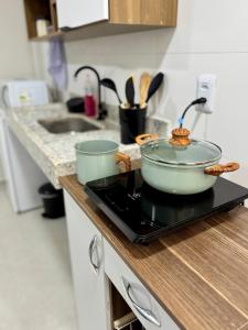 a pot on top of a stove in a kitchen at No centro, em frente à praça in Eunápolis