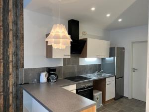 a kitchen with a counter top and a chandelier at Nahe Schlosspark Husum in Husum