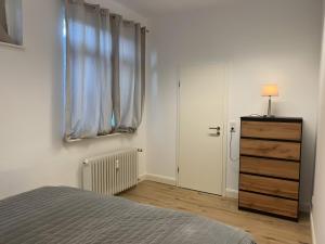 a bedroom with a bed and a dresser and a window at Nahe Schlosspark Husum in Husum