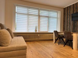 a living room with a couch and a table and a window at Nahe Schlosspark Husum in Husum +4 photos