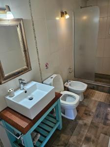 a bathroom with a sink and a toilet and a mirror at MarEz in Punta Del Diablo +60 photos