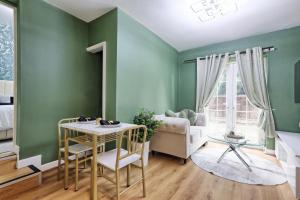 a room with green walls and a table and a couch at Reeha's Hotel Apartments in Southend-on-Sea