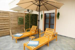 two chairs and an umbrella on a patio at SteMaMaisonette in Afantou