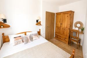 a bedroom with a bed and a wooden cabinet at Little Vine House in Mostar
