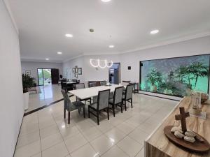 a dining room and living room with a table and chairs at Casa de praia in São Luís