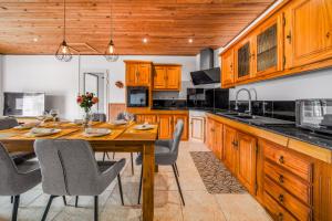 a kitchen with wooden cabinets and a wooden table with chairs at Villa BELLEVUE in Bras-Panon +11 photos