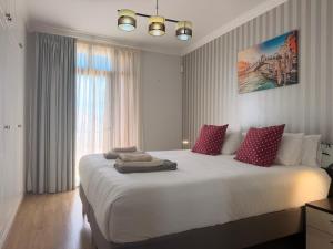 a bedroom with a large white bed with red pillows at Villa Feliz 44 in Meloneras +70 photos