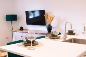 a kitchen with three wine glasses and a sink at The Spa Town Loft in Buxton