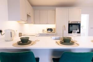a kitchen with two plates and wine glasses on a counter at The Spa Town Loft in Buxton