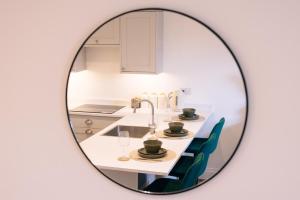 a mirror reflecting a kitchen with a table and chairs at The Spa Town Loft in Buxton +27 photos