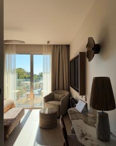 ein Wohnzimmer mit Sofa, Tisch und Fernseher in der Unterkunft Casa C Hôtel & Spa in Propriano