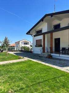 a large white building with a grass yard at AlMi House - Colline del Prosecco in Soligo