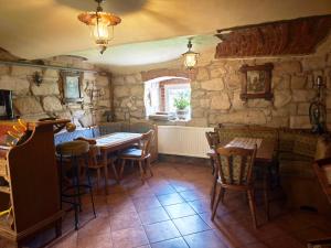 a dining room with tables and chairs and a stone wall at Agroturystyka Pod Leszczyną in Wambierzyce