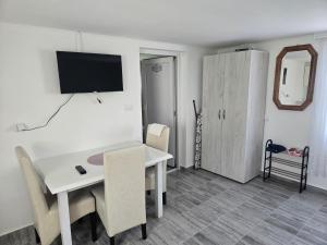 a room with a white table and a tv on the wall at Studio Villa Ruža in Golubac