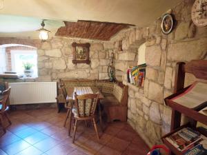 a dining room with a table and a stone wall at Agroturystyka Pod Leszczyną in Wambierzyce +35 photos