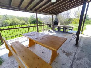 a wooden picnic table and bench on a patio at Nelly's Place 27 in Shkorpilovtsi