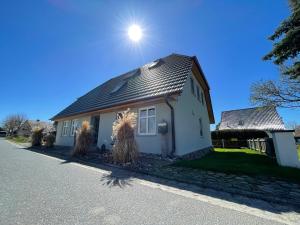 a small white house with the sun in the sky at Jasmunder Boddenhuus 37 in Glowe