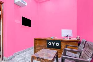 a pink wall with a desk and two chairs at Hotel O Elegant Stay CDA in Cuttack