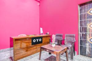 a pink wall with a desk and two chairs at Hotel O Elegant Stay CDA in Cuttack