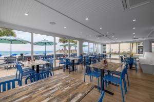 a restaurant with tables and chairs and a view of the ocean at Beachy 5th Floor Oceanfront Room in Pawleys Island