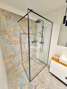 a shower with a glass door in a bathroom at Apartament Nieznany Bór in Hajnówka