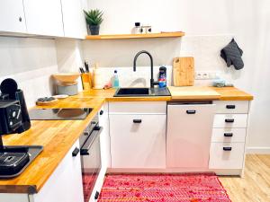 a kitchen with white cabinets and a sink at Apartament Nieznany Bór in Hajnówka +18 photos