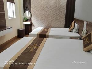 a bedroom with two beds and a mirror at Ngọc Tùng Hotel in Ha Long
