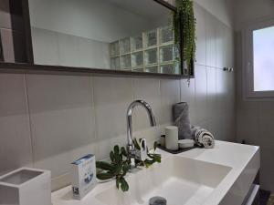 a white sink in a bathroom with a mirror at Casa Ghjuvanna in Propriano +8 photos