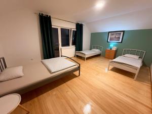 a room with two beds in a room with wooden floors at holiday home RIVER HOUSE in Jajce