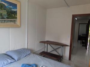 a bedroom with a table and a bed and a table at Condomínio Containers está localizado a 900m do centro de Morretes, local calmo e em meio a mata Atlântica in Morretes