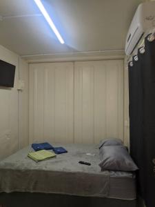 a room with a bed with a light on it at Condomínio Containers está localizado a 900m do centro de Morretes, local calmo e em meio a mata Atlântica in Morretes +8 photos