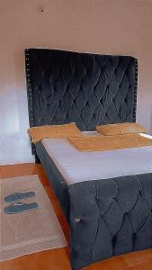 a bed with a black headboard with at Honeymoon villah in Diani Beach