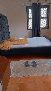 a bed with a pair of shoes on the floor at Honeymoon villah in Diani Beach +24 photos