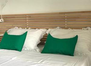 a bed with green and white pillows on it at Casa Sirolli in Archi