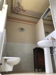 a white bathroom with a sink and a mirror at Casa Sirolli in Archi