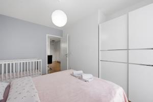 a white bedroom with a bed and a glass wall at Apartman Tonka in Šibenik