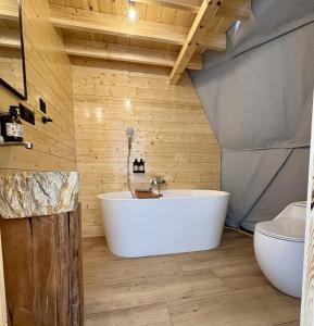 a bathroom with a white tub and a toilet at Niespiesznie in Suwałki
